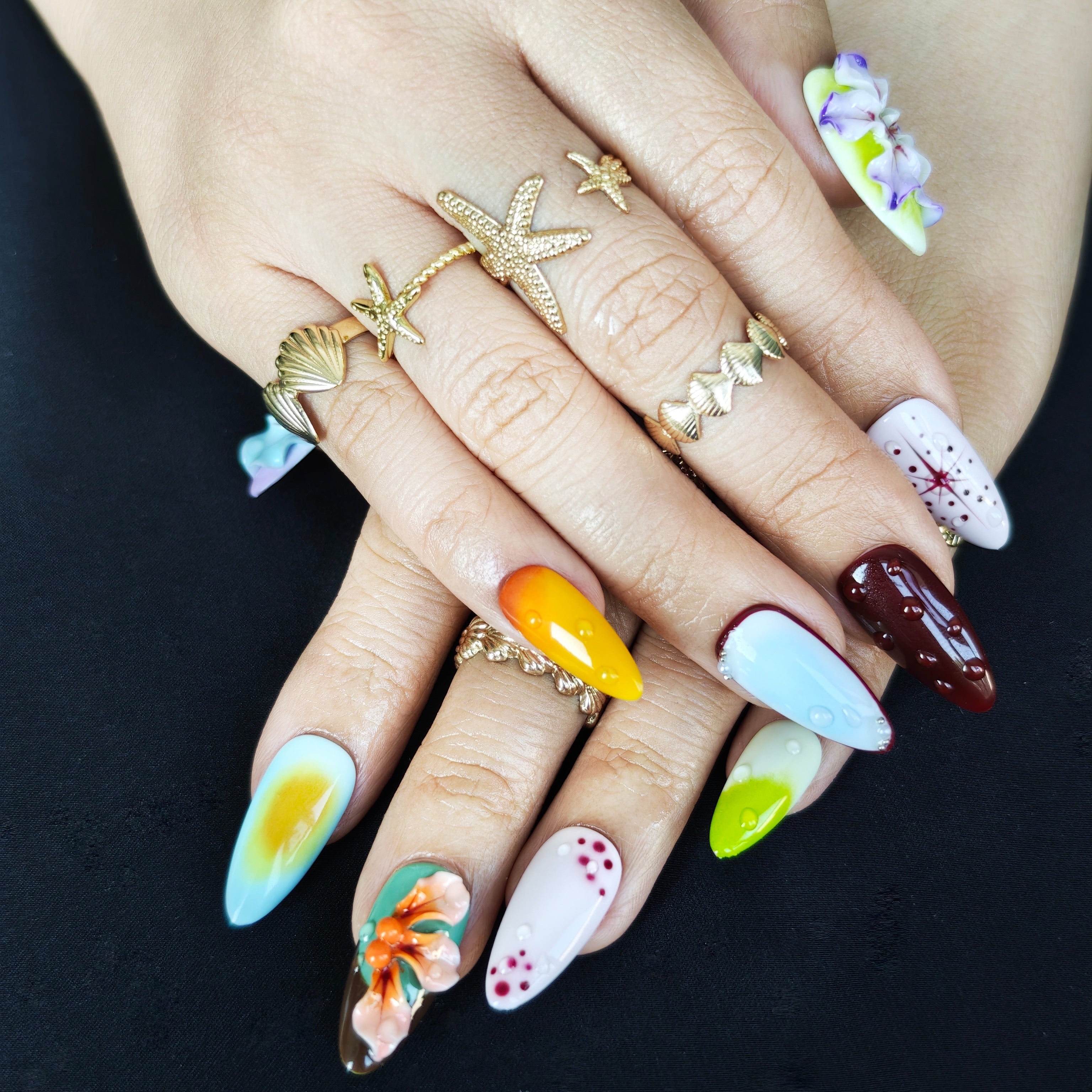 Elegant almond press on nails with handmade floral nail art for vacation and party looks