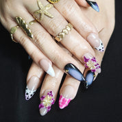 Almond press-on nails in black and purple with vibrant 3D floral designs, perfect for a bold, edgy style.