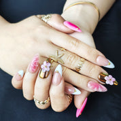 Elegant almond press-on nails in pink and gold with handmade 3D floral designs, French style, and a soft peach summer vibe.