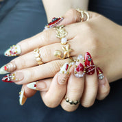 Hand wearing Pearl Ruby gothic almond press-on nails with vintage dark feminine nail art style
