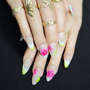 Hand wearing Island Bloom tropical floral almond press-on nails with elegant vacation manicure style