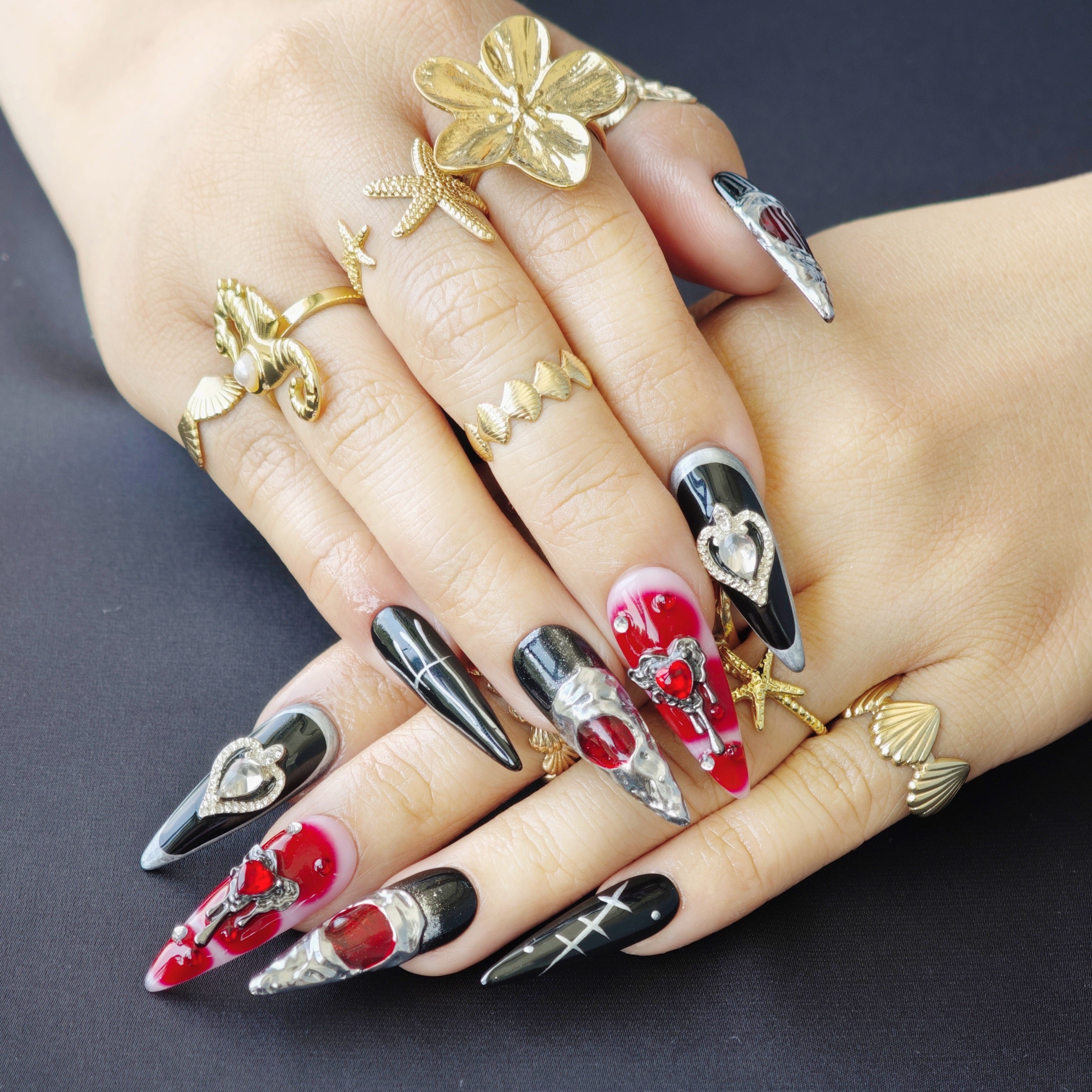 Black and red gothic stiletto press-on nails with silver crystal hearts, perfect for dark and edgy style lovers.