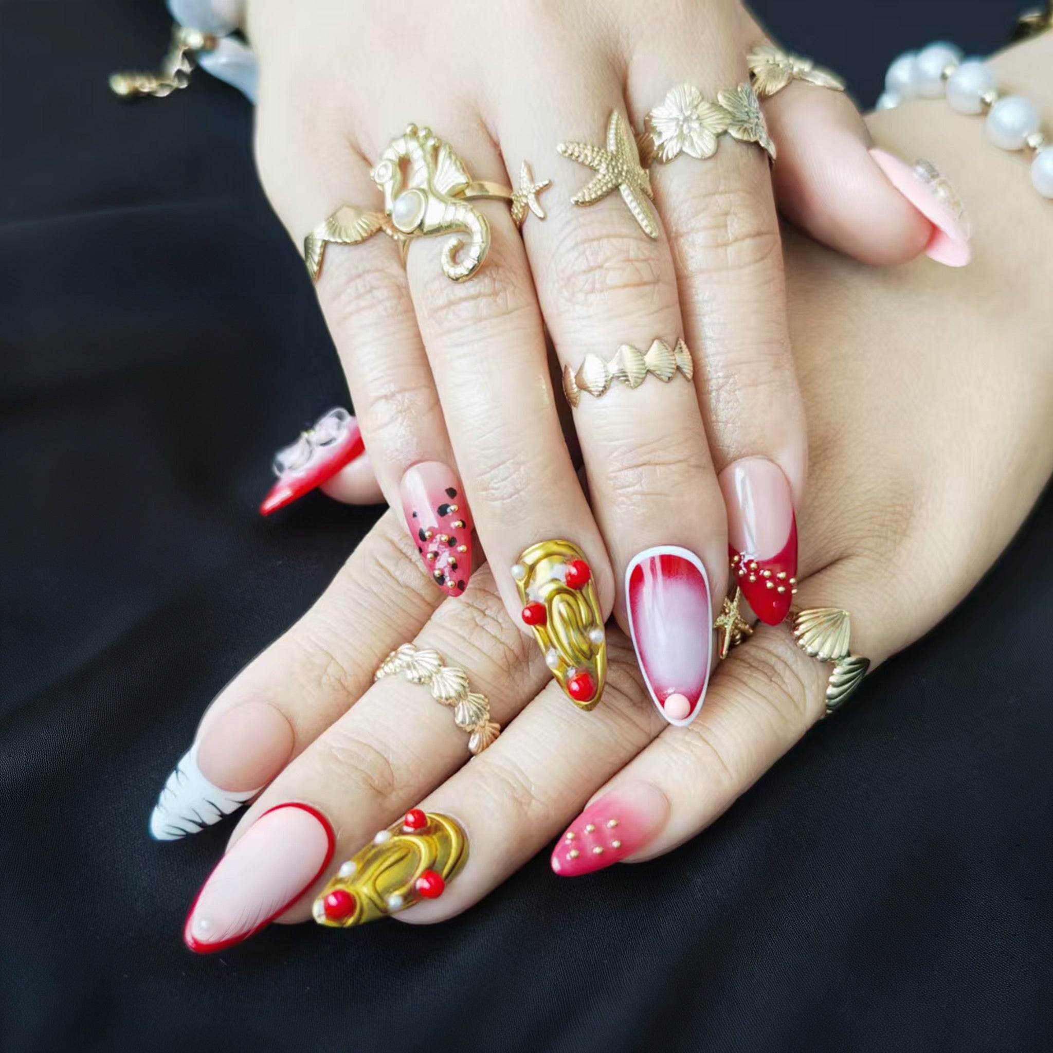 Red and gold transparent press-on nails with large 3D handcrafted petals, featuring an intricate luxury design.