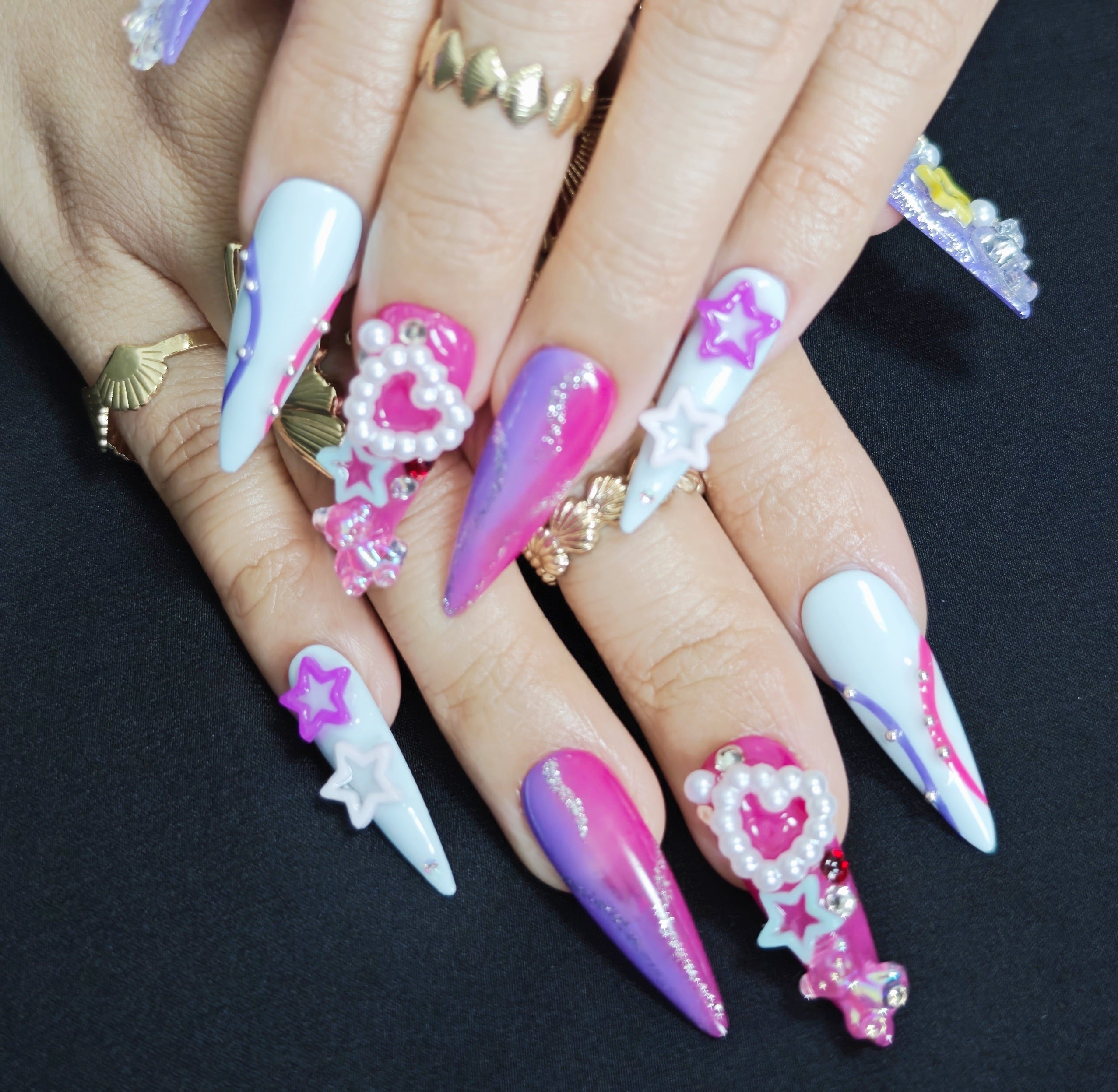 Woman wearing Y2K Candy stiletto press-on nails with 3D charms, colorful Y2K designs, and bold trendy party manicure style