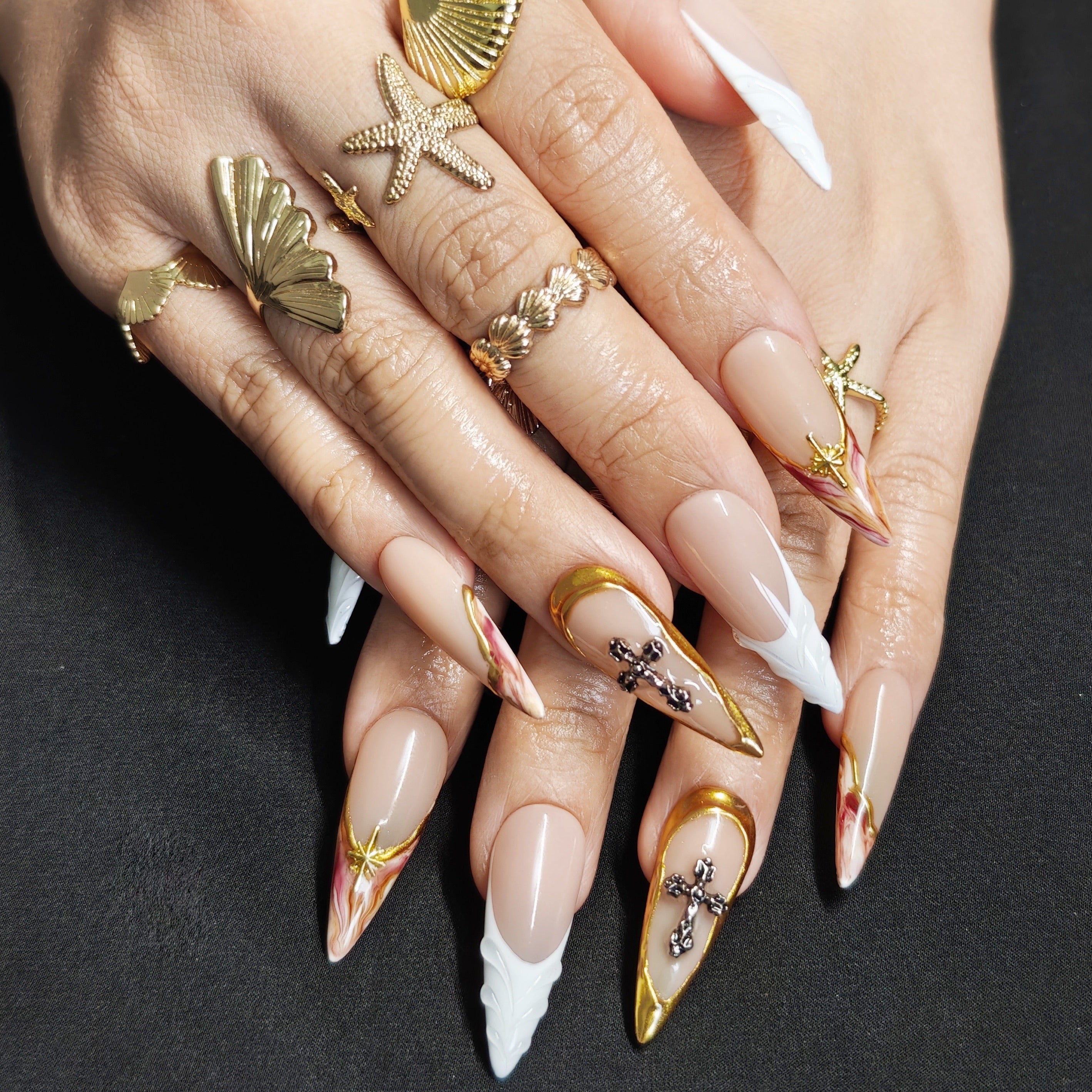 Woman wearing Divine Gold stiletto press-on nails with elegant gold details, vintage inspired design, and sophisticated luxury manicure style