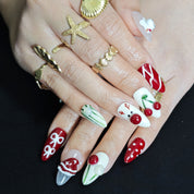 Red and white almond press-on nails with 3D snowman, cherry, Santa hat, bow, and reindeer designs for festive Christmas style.