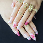 Woman wearing Fairy Pink 3D flower almond press-on nails with soft pink gradient, ocean inspired details, and elegant summer manicure style