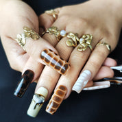 Close-up detail of Wild Safari handmade press-on nails featuring tortoise shell patterns snake textures metallic charms and 3D details
