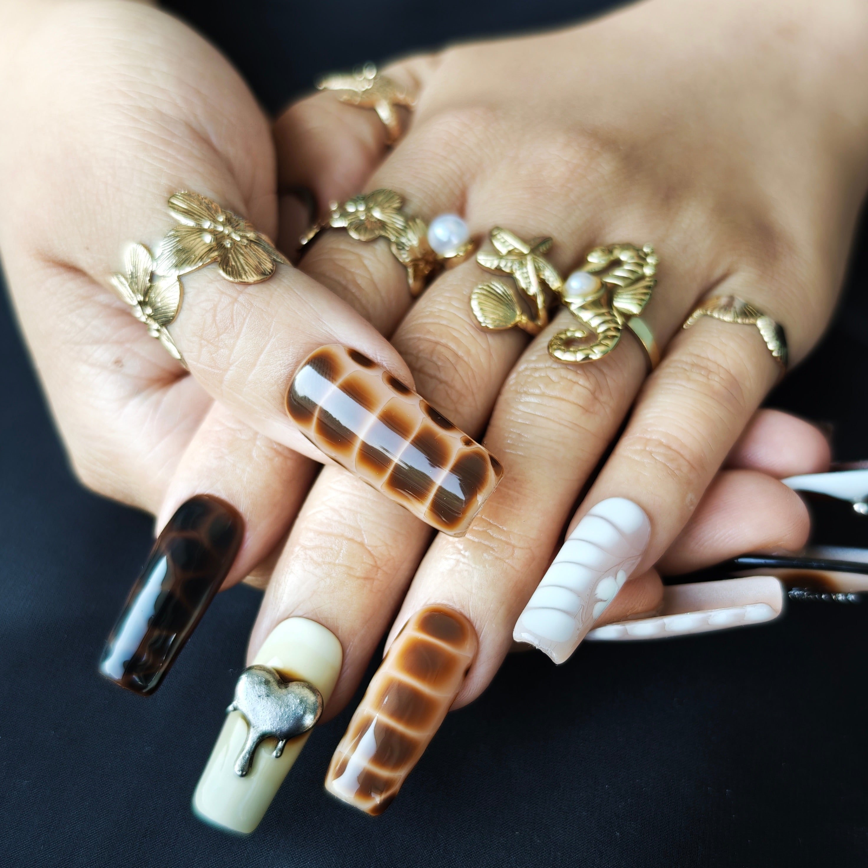 Close-up detail of Wild Safari handmade press-on nails featuring tortoise shell patterns snake textures metallic charms and 3D details