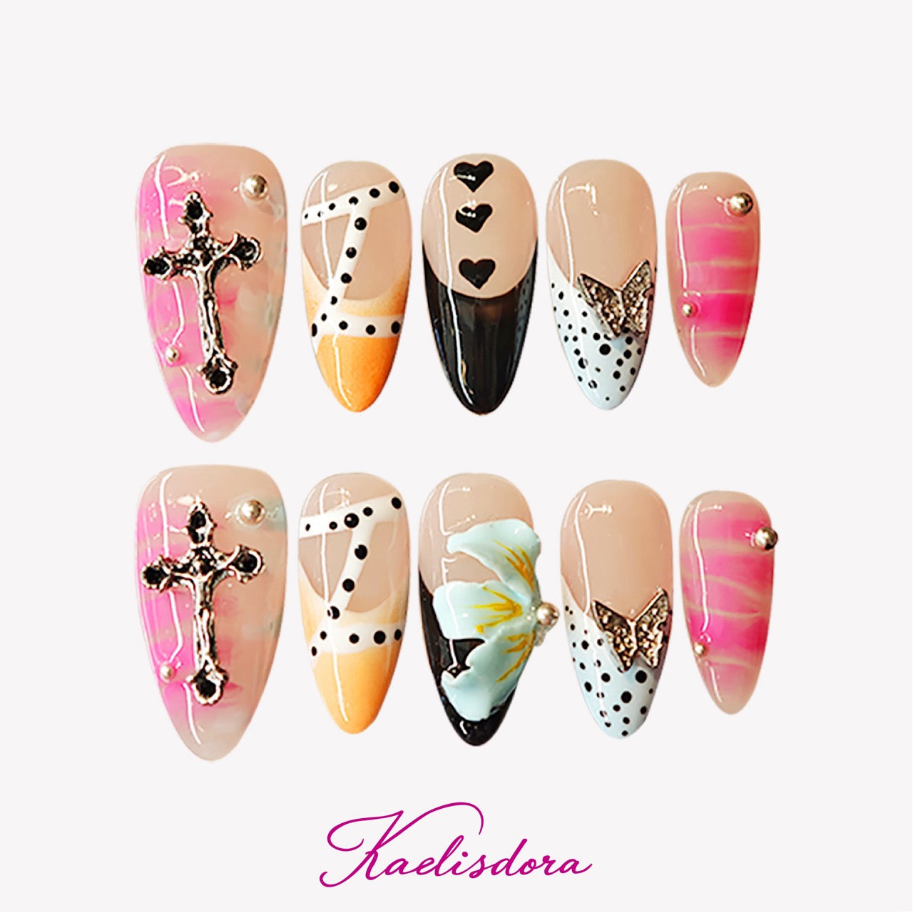 Almond press-on nails in yellow with pink cross, blue floral accents, and silver butterfly decorations.
