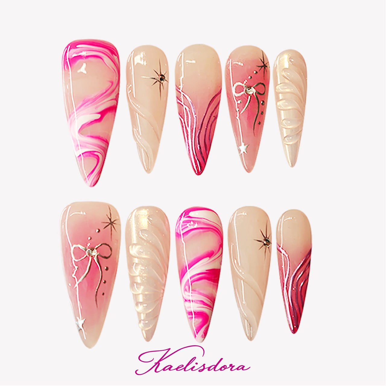Pink Riot stiletto press-on nails featuring pink marble fluid design, white bow details, crystal accents, and handmade luxury nail art
