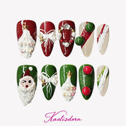 Red and green almond press-on nails with 3D Santa, Christmas tree, and wreath designs for festive holiday style.