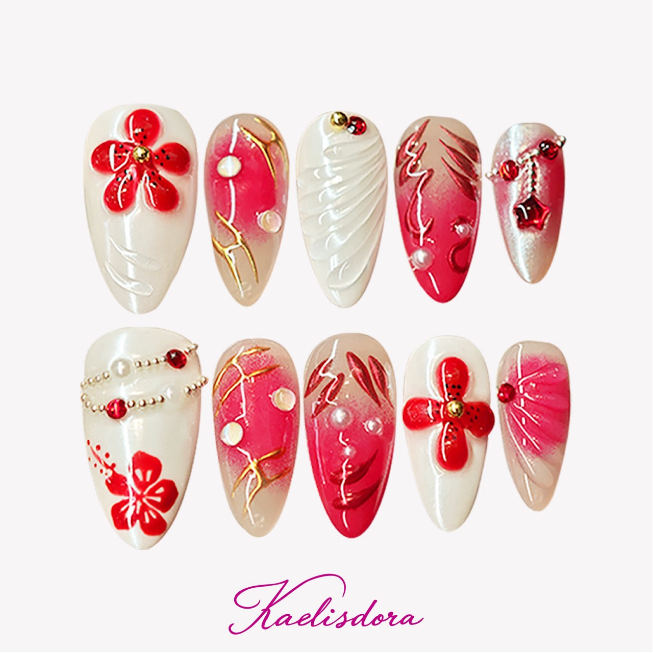 White and red almond press-on nails with 3D floral designs, rhinestones, pearls, and gold bead accents for a luxurious handmade look.