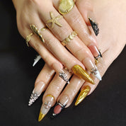 Close up of sculpted gold wave details and crystal accents on luxury press on nails