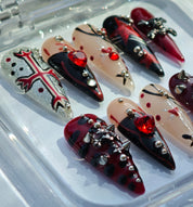 Close-up detail of Gothic Heart handmade press-on nails featuring metal chains studs cross decorations and glitter accents